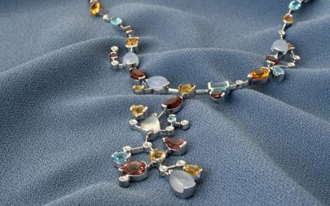 Gold estate jewelry, diamond pendant, and jeweler loupe on an evaluation desk