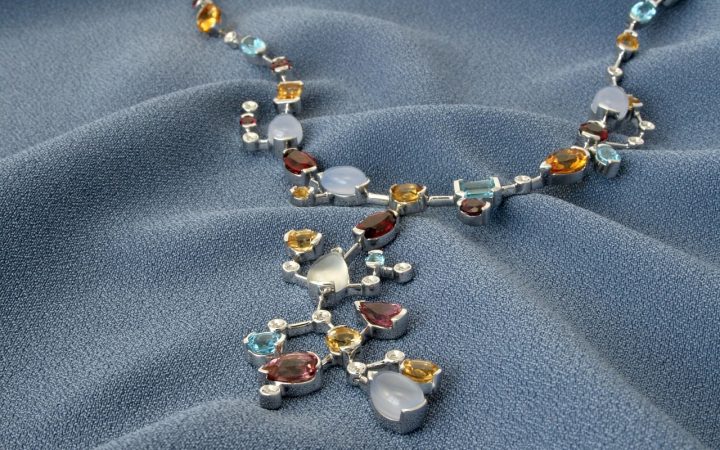 Gold estate jewelry, diamond pendant, and jeweler loupe on an evaluation desk