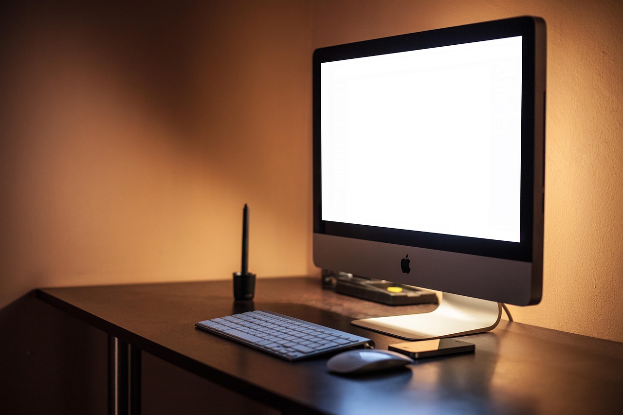 Monitors displaying clean text markup and system status in a dimly lit workstation.