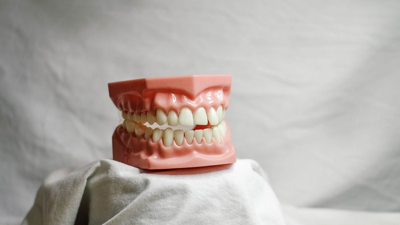 A young child at a pediatric dental checkup discussing tooth care with a dentist.
