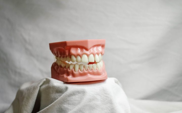 A young child at a pediatric dental checkup discussing tooth care with a dentist.
