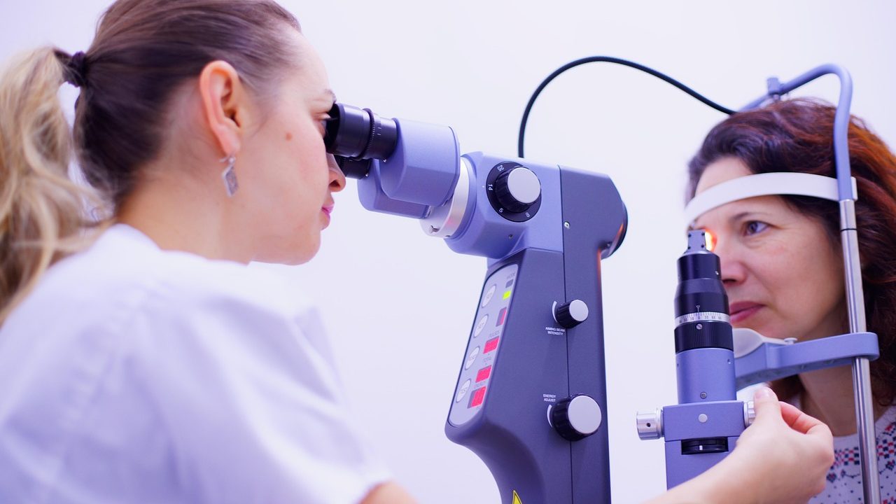 Child receiving a comprehensive eye examination from an optometrist in a bright clinic setting.