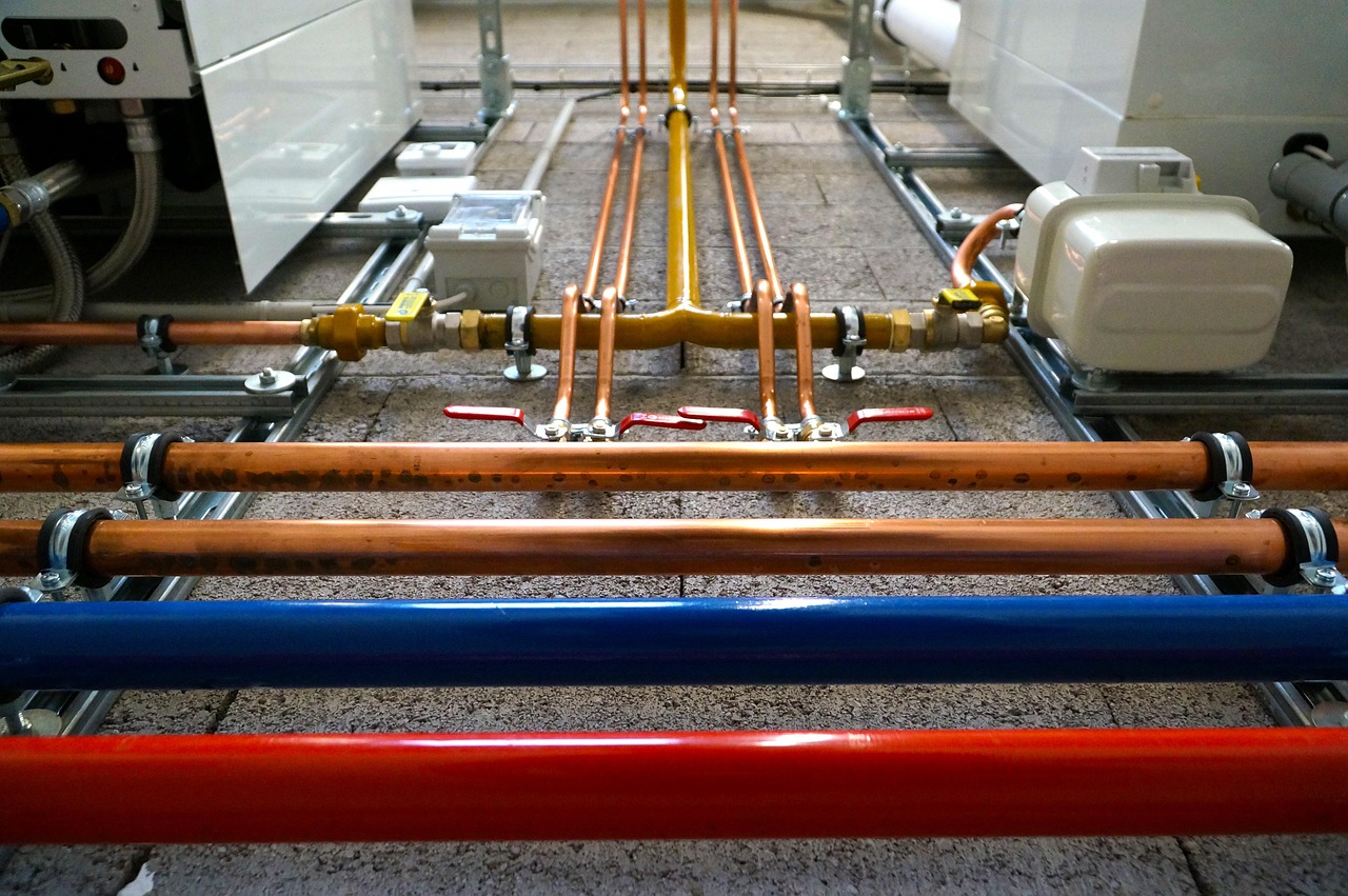 Central plumbing manifold system with organized red and blue PEX lines mounted on an exposed interior wall.