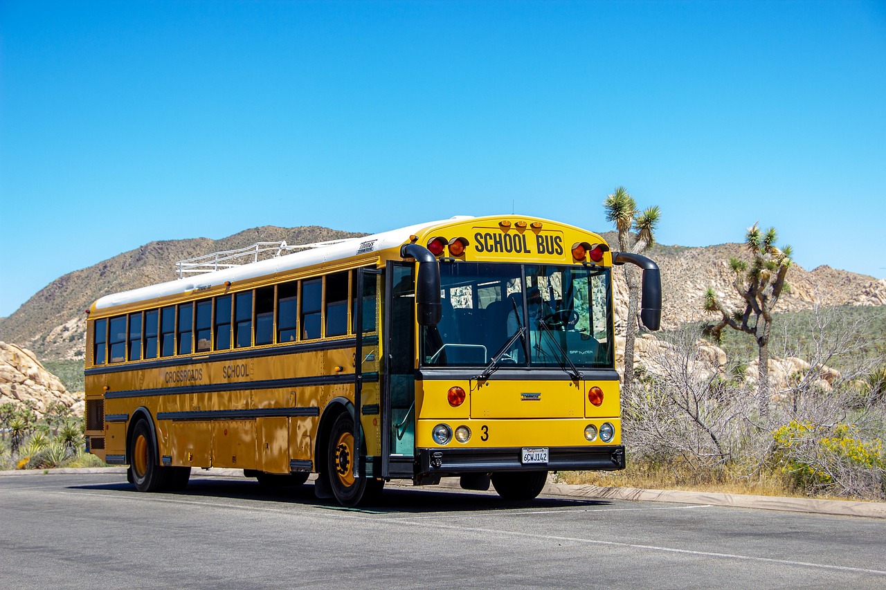 Young children walking toward a yellow school bus
