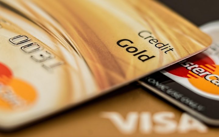 A modern leather wallet and credit cards next to an open quarterly spending calendar on a bright wooden desk.