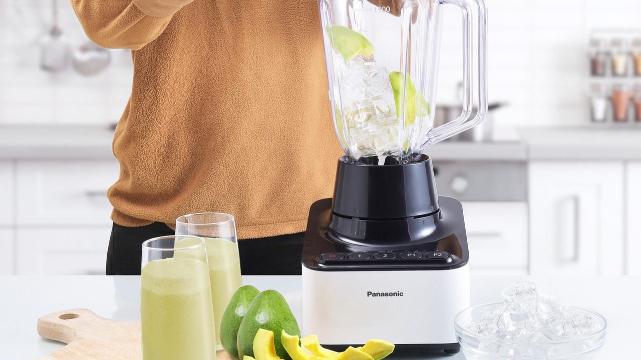 A stainless steel commercial food processor sitting on a clean kitchen countertop.