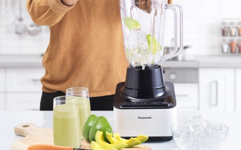 A stainless steel commercial food processor sitting on a clean kitchen countertop.