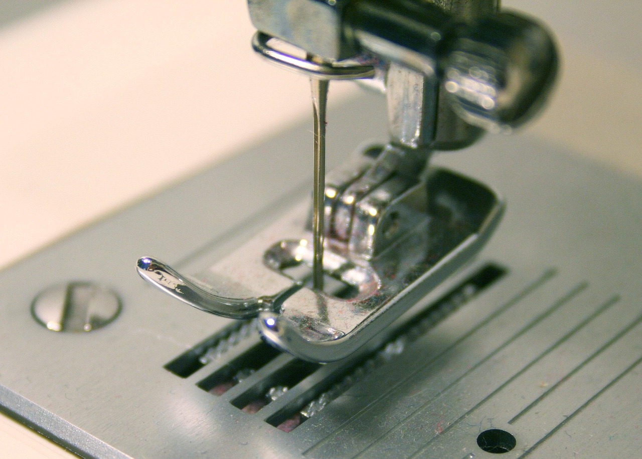 Close-up detail of an industrial sewing machine rotary hook and needle bar mechanism