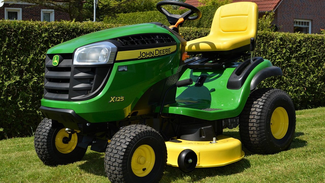 Commercial zero-turn riding mower under mechanical inspection in a professional service bay.