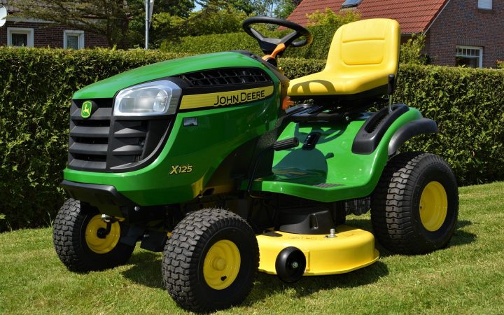 Commercial zero-turn riding mower under mechanical inspection in a professional service bay.