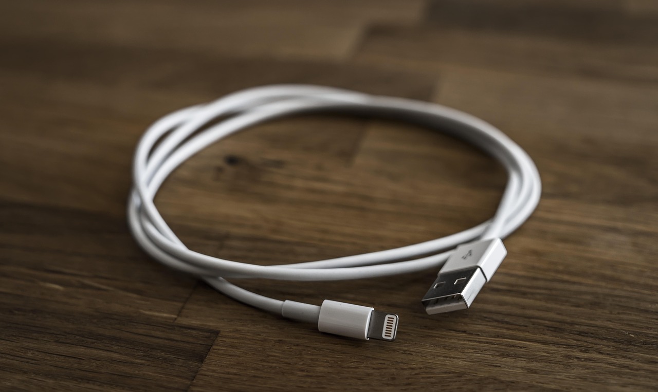 Close-up of a worker connecting a USB-C cable into a laptop dock.