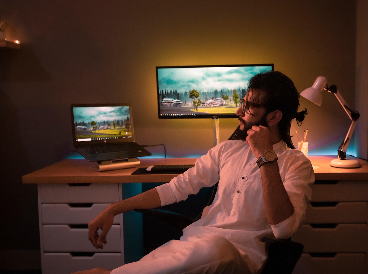Dual computer monitors displaying office software on a modern wooden desk.