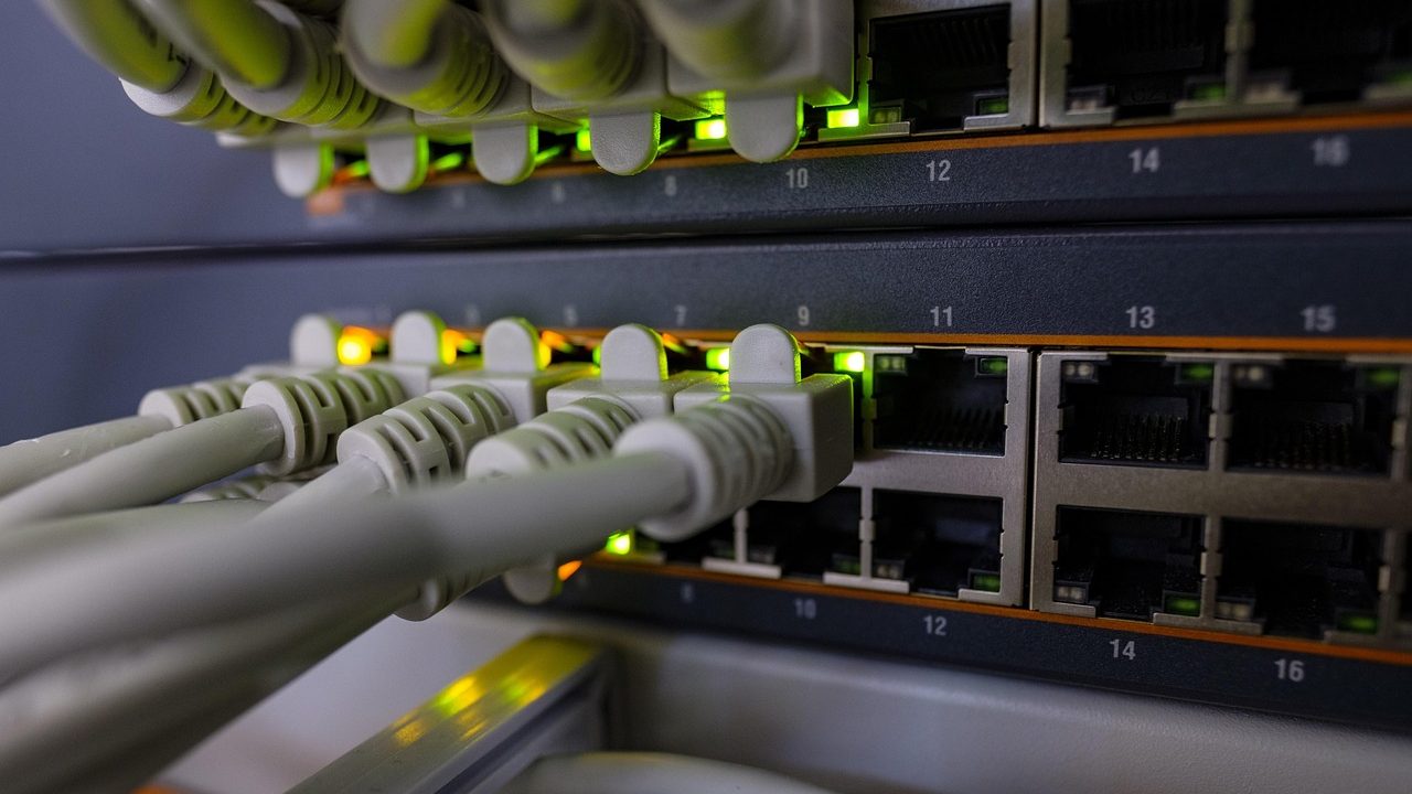 Close-up of a person plugging an Ethernet cable into a modern white router.