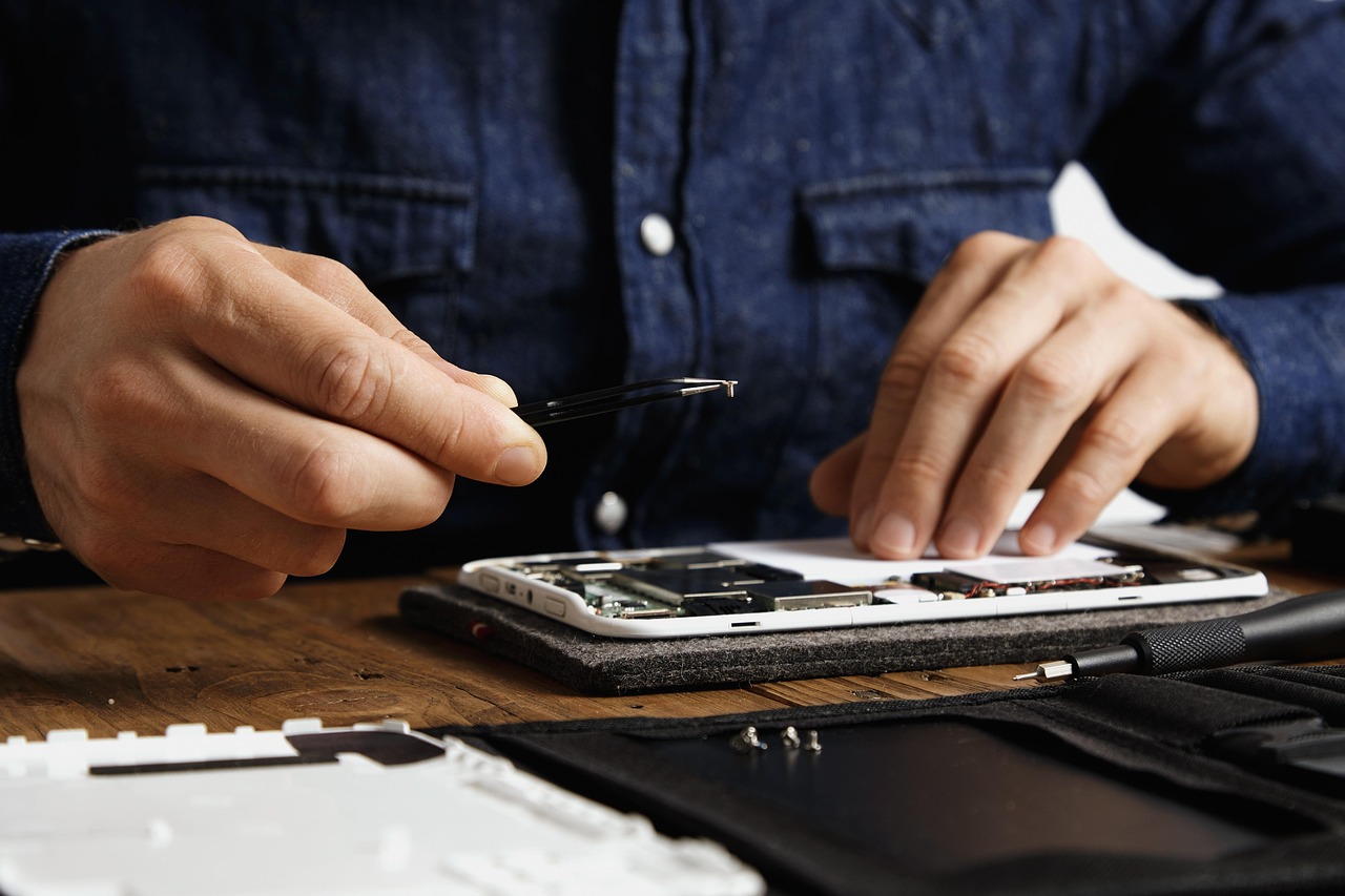 Close-up of a technician inspecting computer hardware at a workbench.