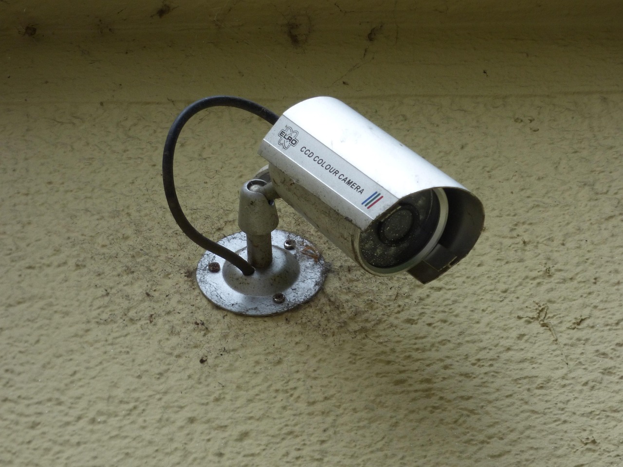 A homeowner inspecting a smart security camera on a workbench.