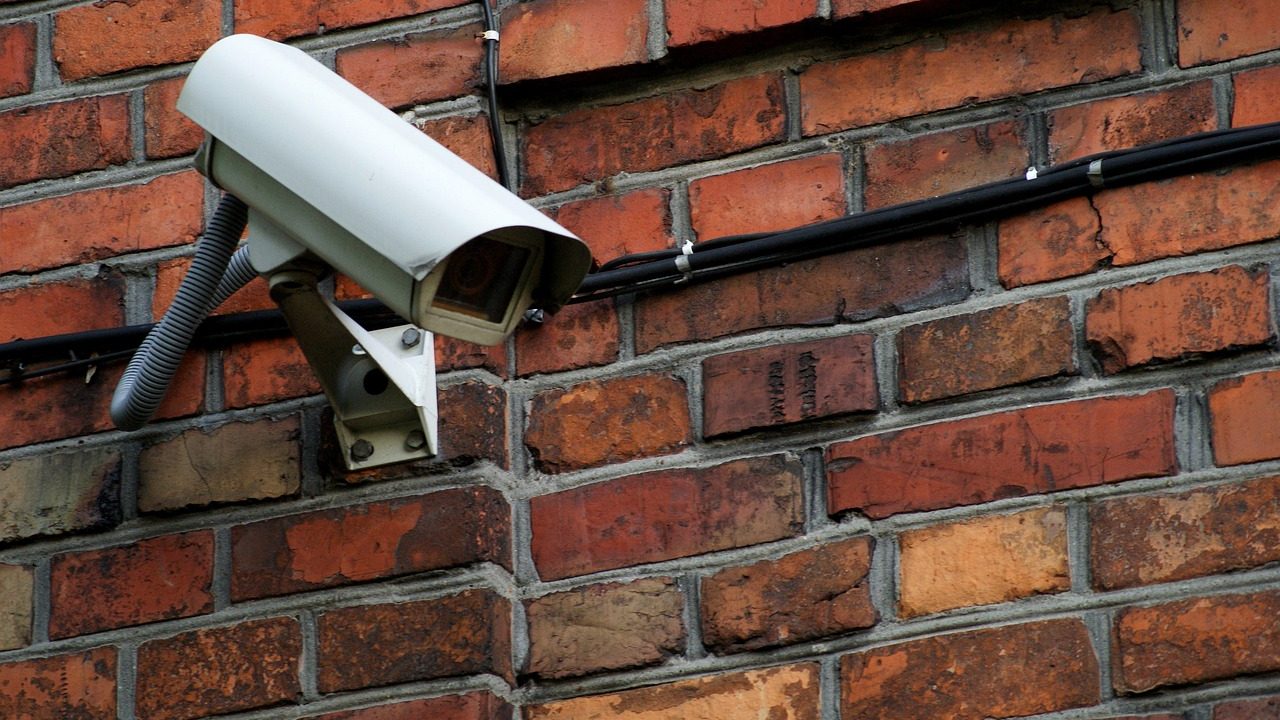 A modern smart security camera mounted securely on a residential exterior wall.