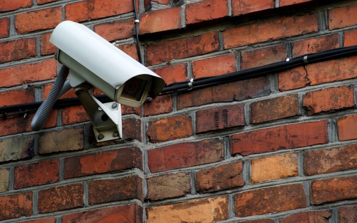 A modern smart security camera mounted securely on a residential exterior wall.