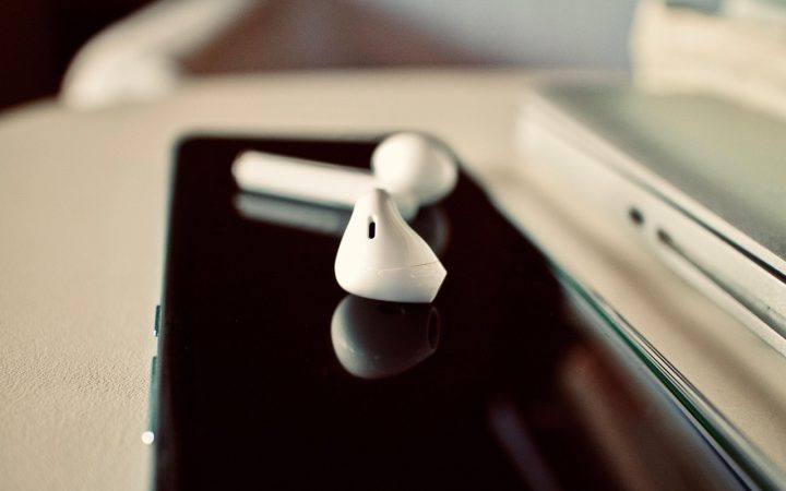 Close-up of a consumer holding a charging case and wireless earbuds for inspection