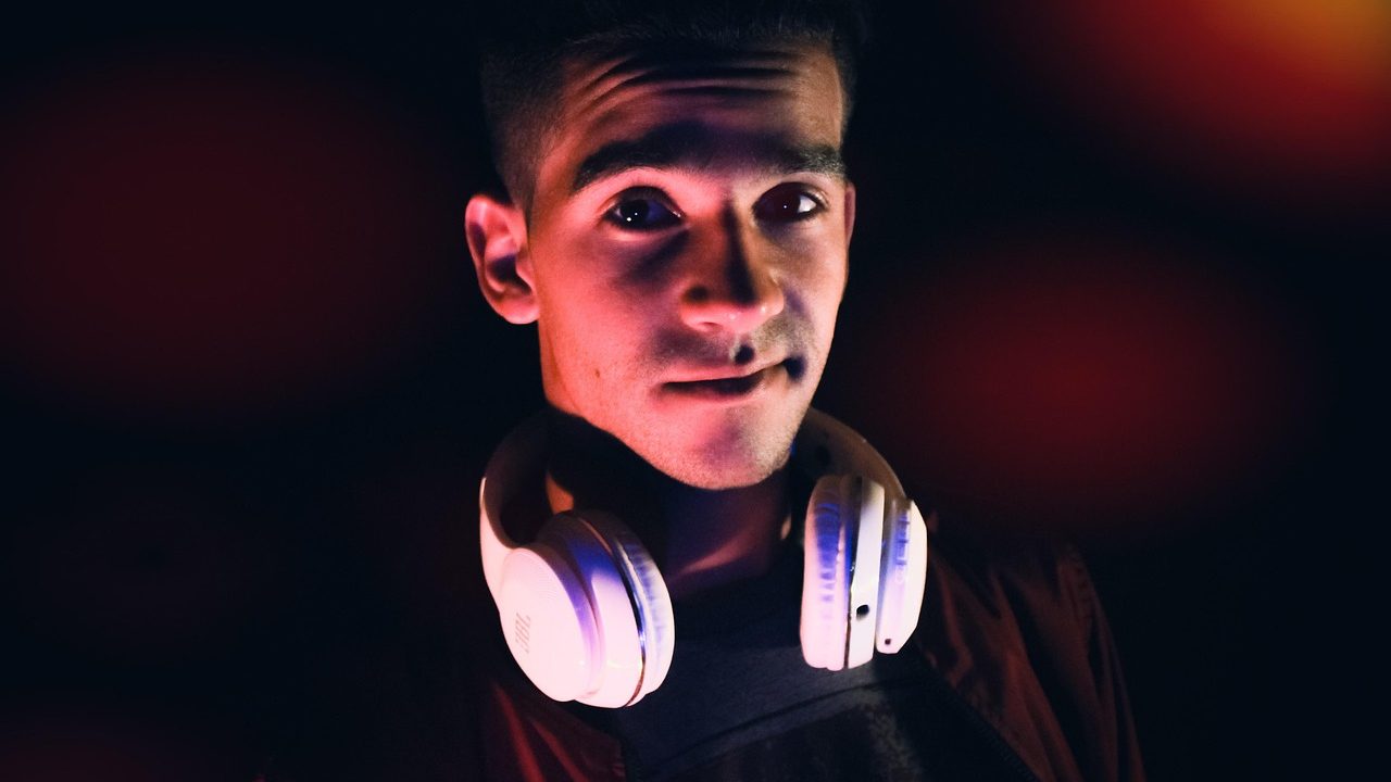 Gamer wearing a wireless gaming headset while testing audio setup at a desk