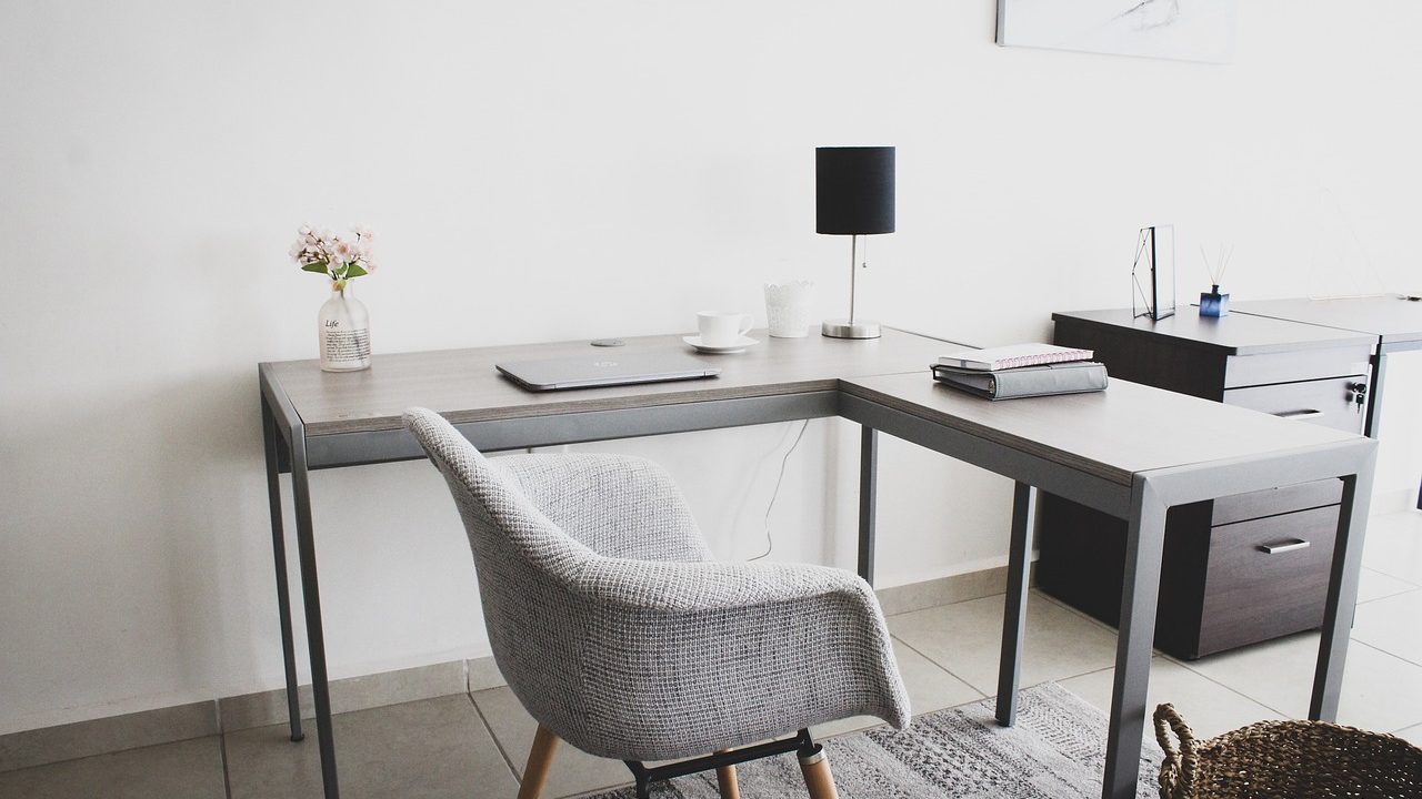 Enterprise managed network switch on a home office desk connected to a corporate laptop.