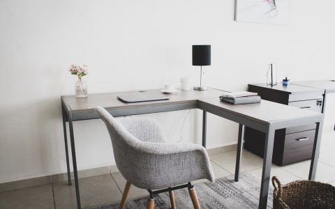 Enterprise managed network switch on a home office desk connected to a corporate laptop.