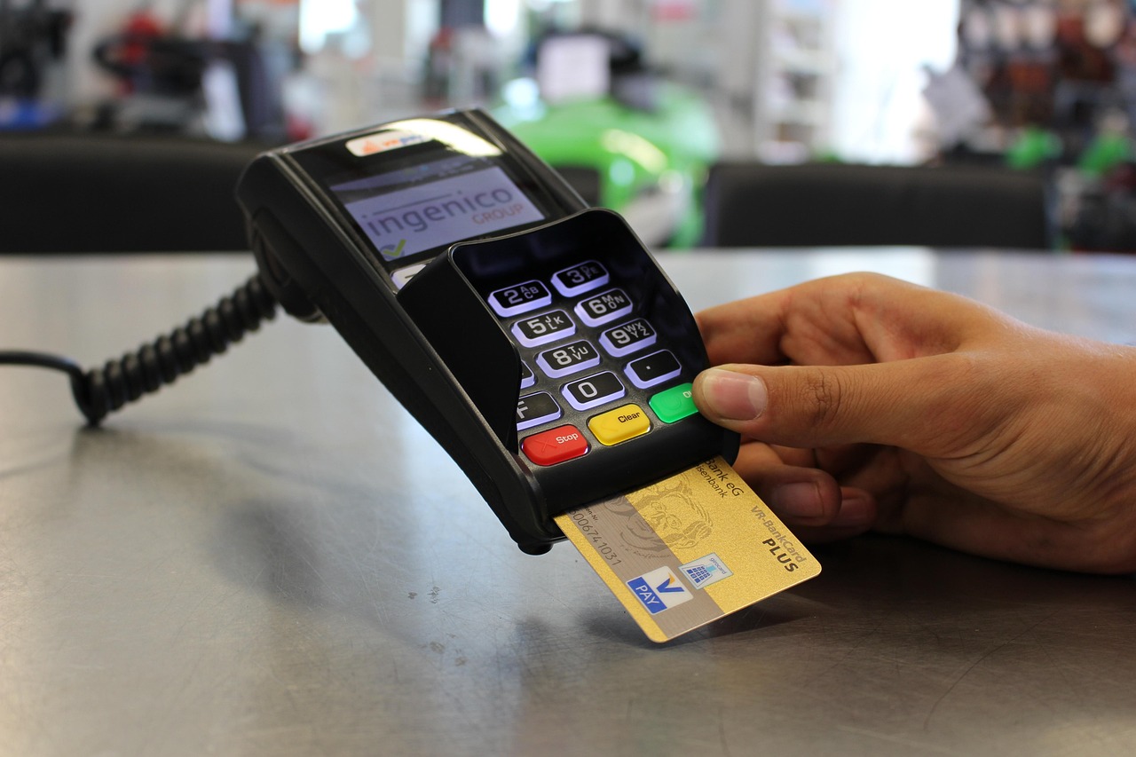 A consumer calculating monthly payments on credit card statements at a desk