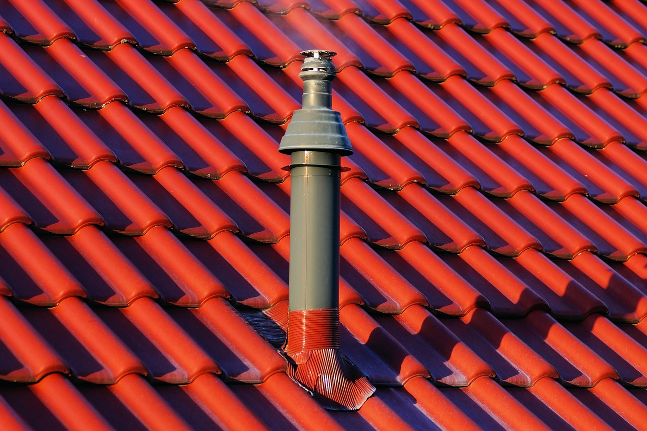 Applying polyurethane roof sealant along the joint of step flashing and exterior siding.