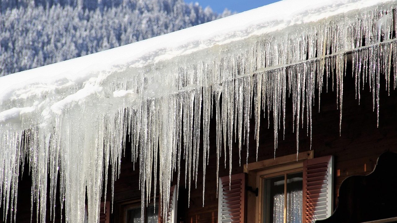 Heavy icicles and snow accumulation on residential roof edge