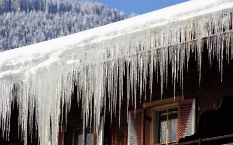 Heavy icicles and snow accumulation on residential roof edge