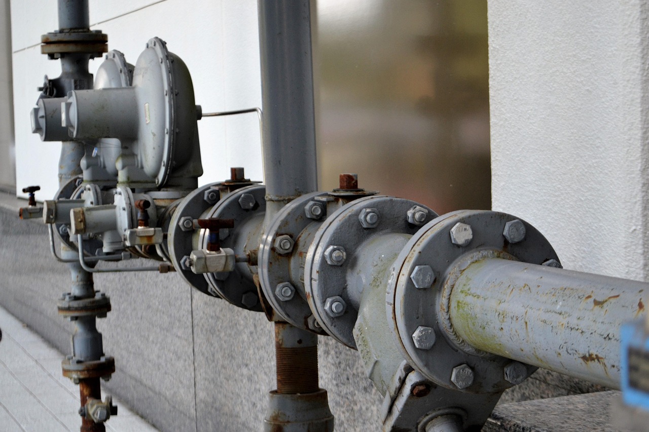 Close-up of hands using a wrench on a brass plumbing fitting
