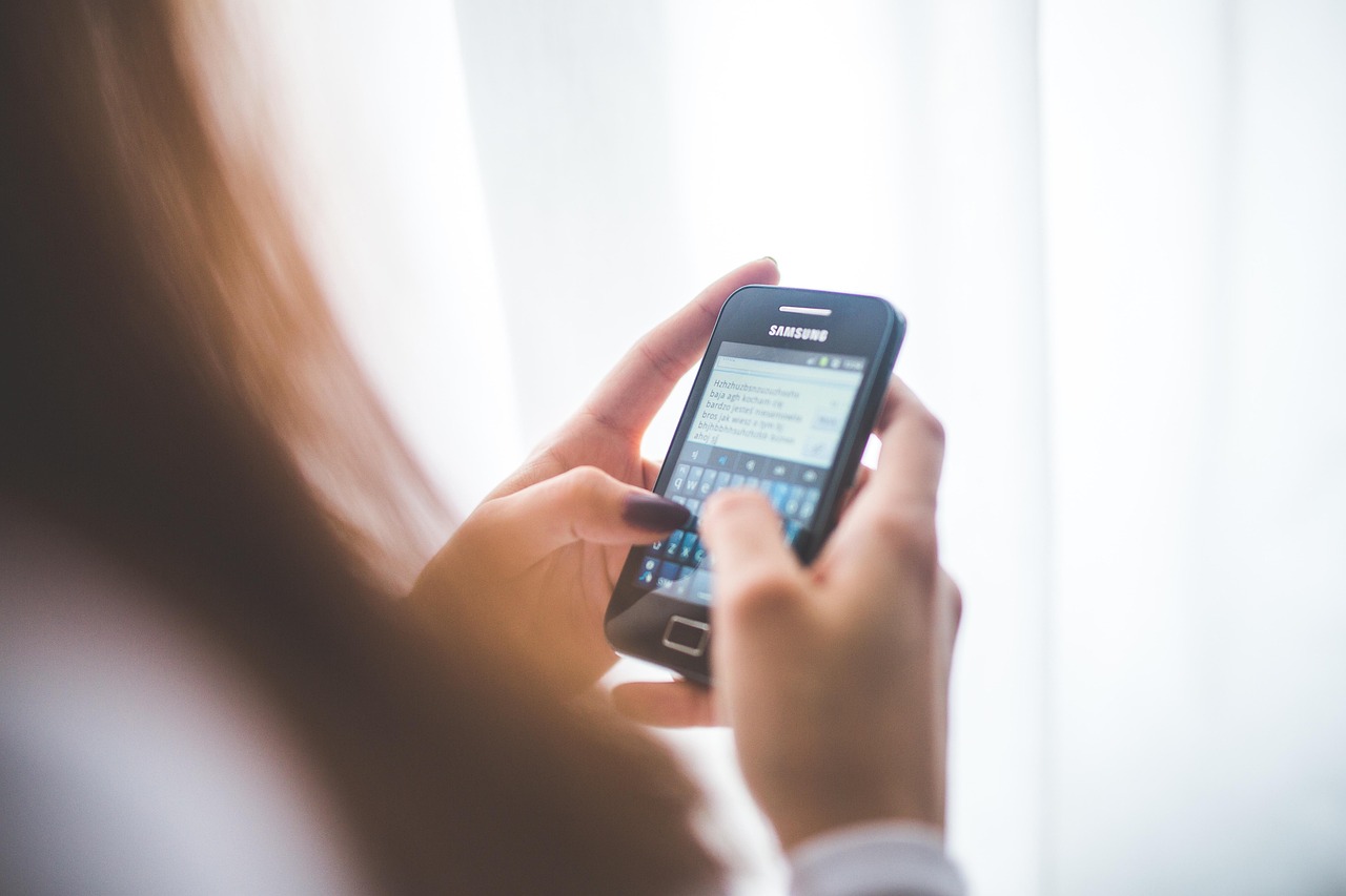 A homeowner using a smartphone application to manage lawn irrigation schedules.