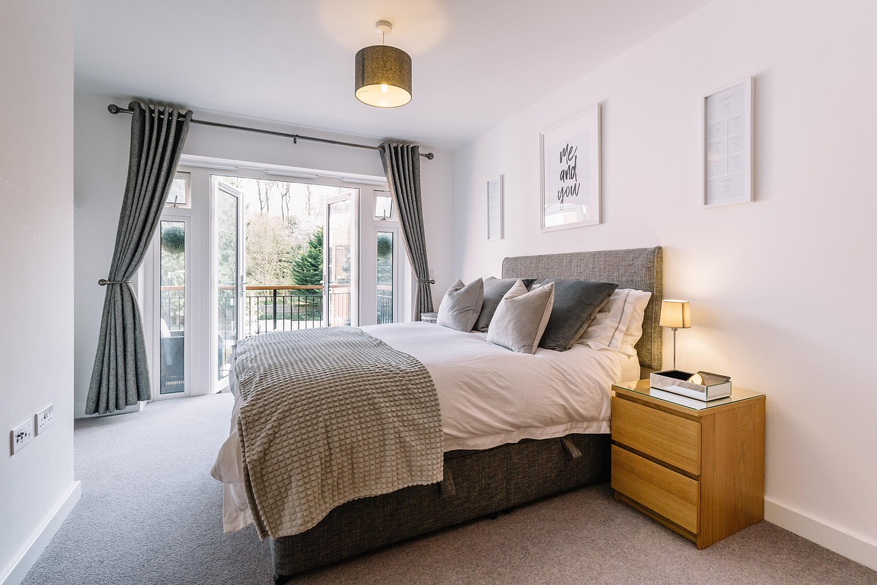 Thick insulated thermal curtains hanging over a bedroom window to block direct heat.