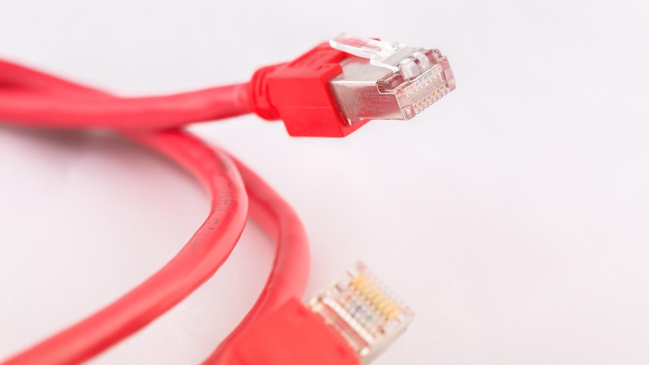 Close-up of a person plugging a power cord into a wall outlet