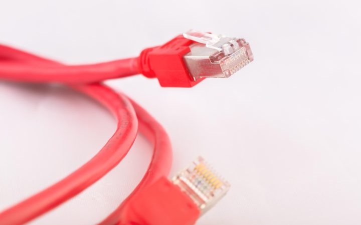 Close-up of a person plugging a power cord into a wall outlet