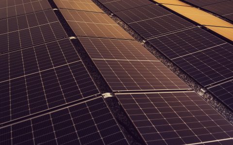 Suburban home equipped with rooftop solar panels and modern utility power grid connections.