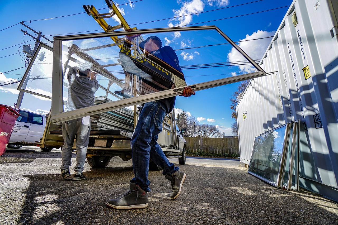 Professional contractor applying adhesive solar control window film to a residential glass pane.