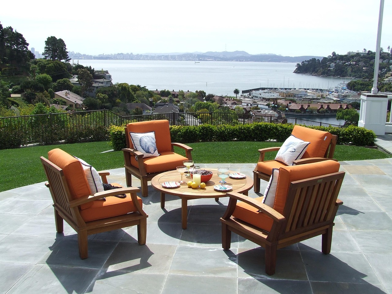 Retractable fabric awning extended over a sunny backyard patio and large windows.