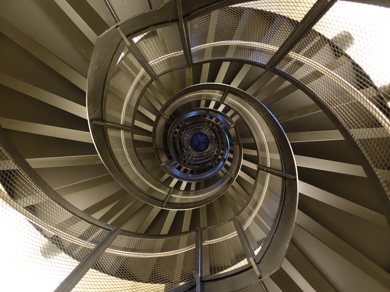 Staircase featuring modern metal balusters and a polished wooden handrail