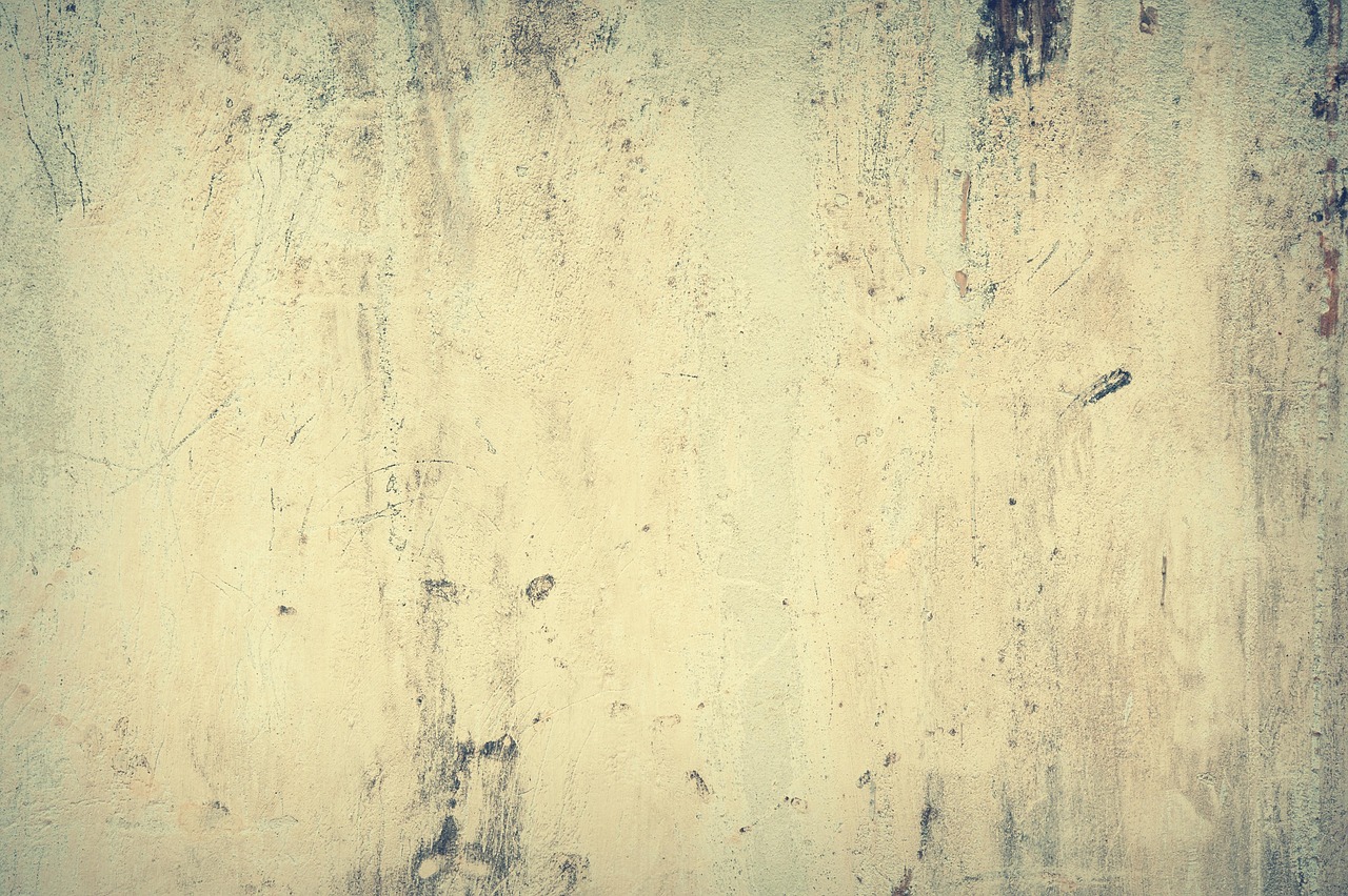 Close-up of hairline cracks and spiderweb fracturing on a stucco surface