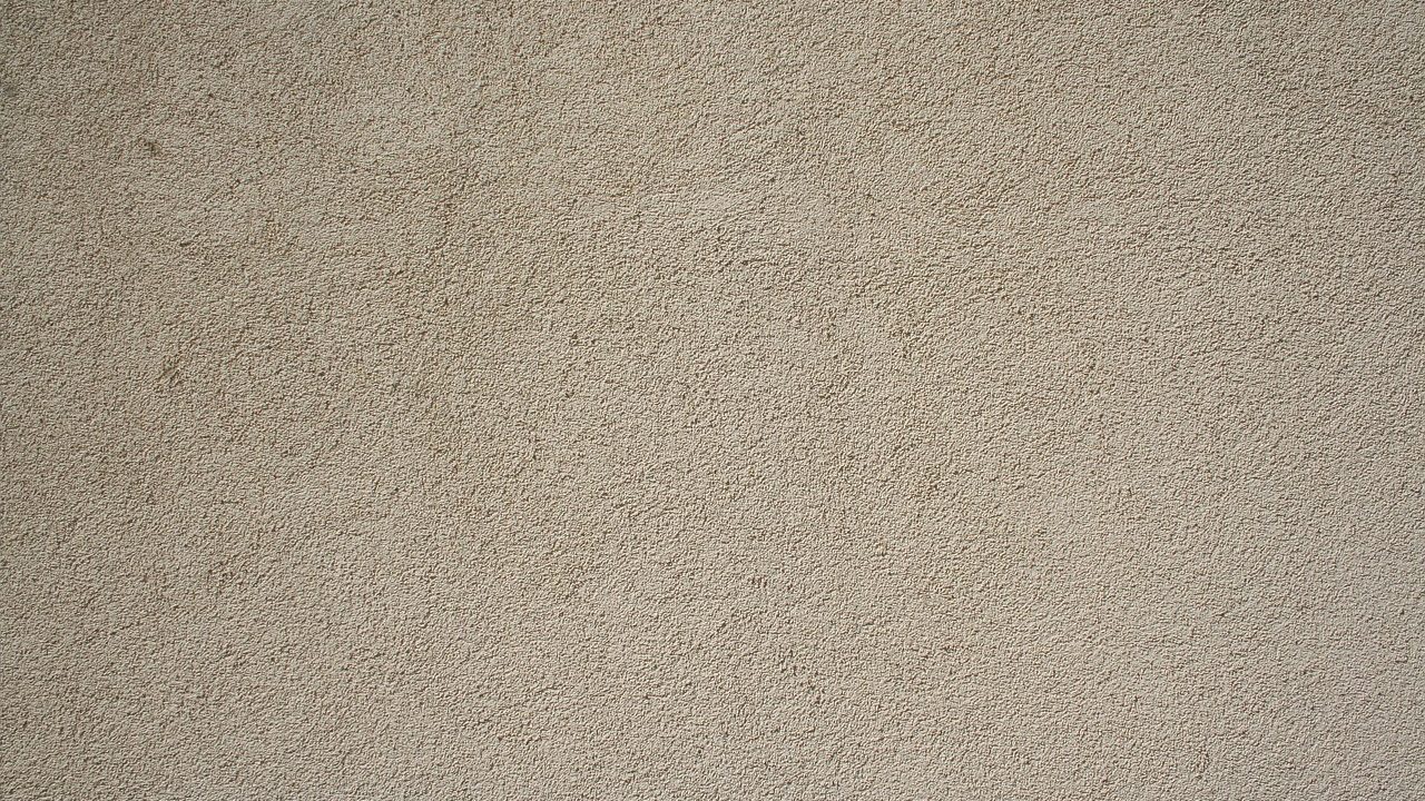 Contractor applying mortar patch to an exterior stucco wall