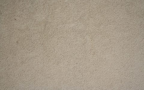 Contractor applying mortar patch to an exterior stucco wall