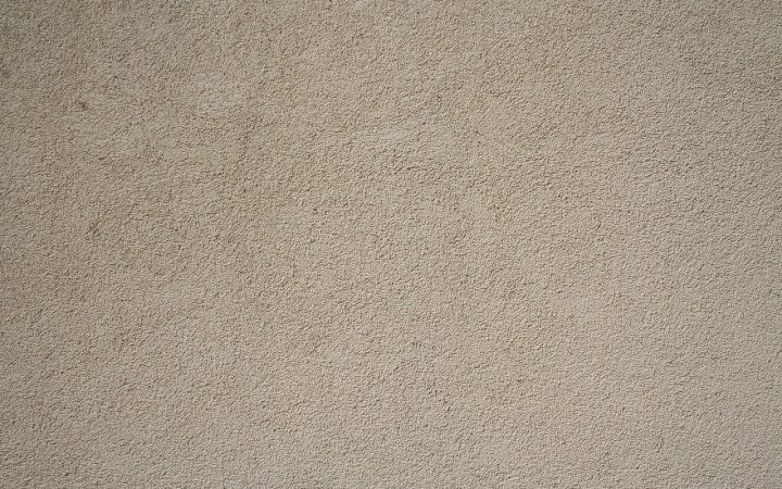 Contractor applying mortar patch to an exterior stucco wall