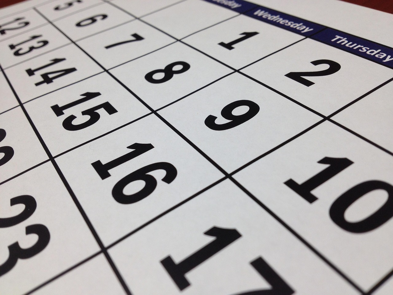 Calendar page with circled dates sitting beside receipts and registration paperwork on a desk.