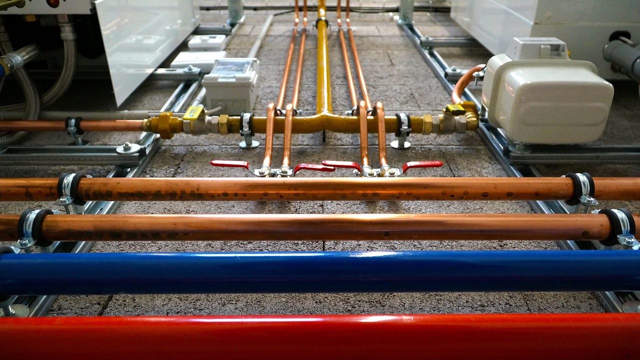Open residential tankless water heater revealing internal plumbing components and wiring