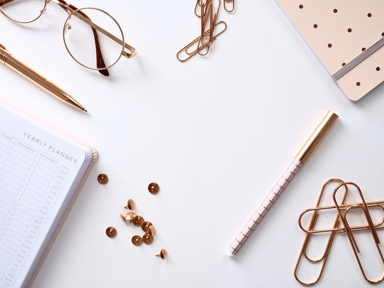 A neatly organized workplace desk displaying a strategic planning notebook and calendar schedule.