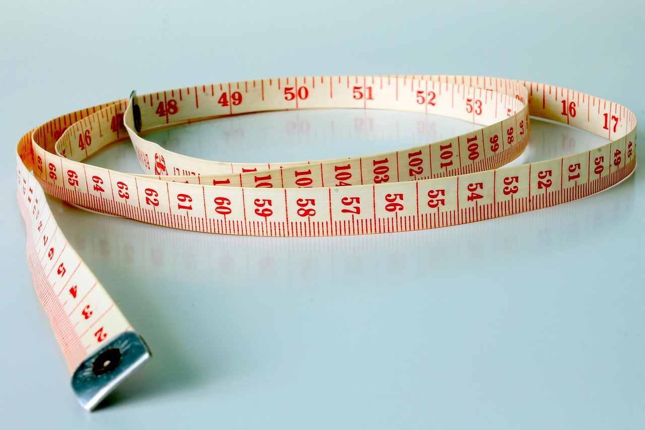 Close-up of a two-by-two inch official passport photo being measured for size compliance.