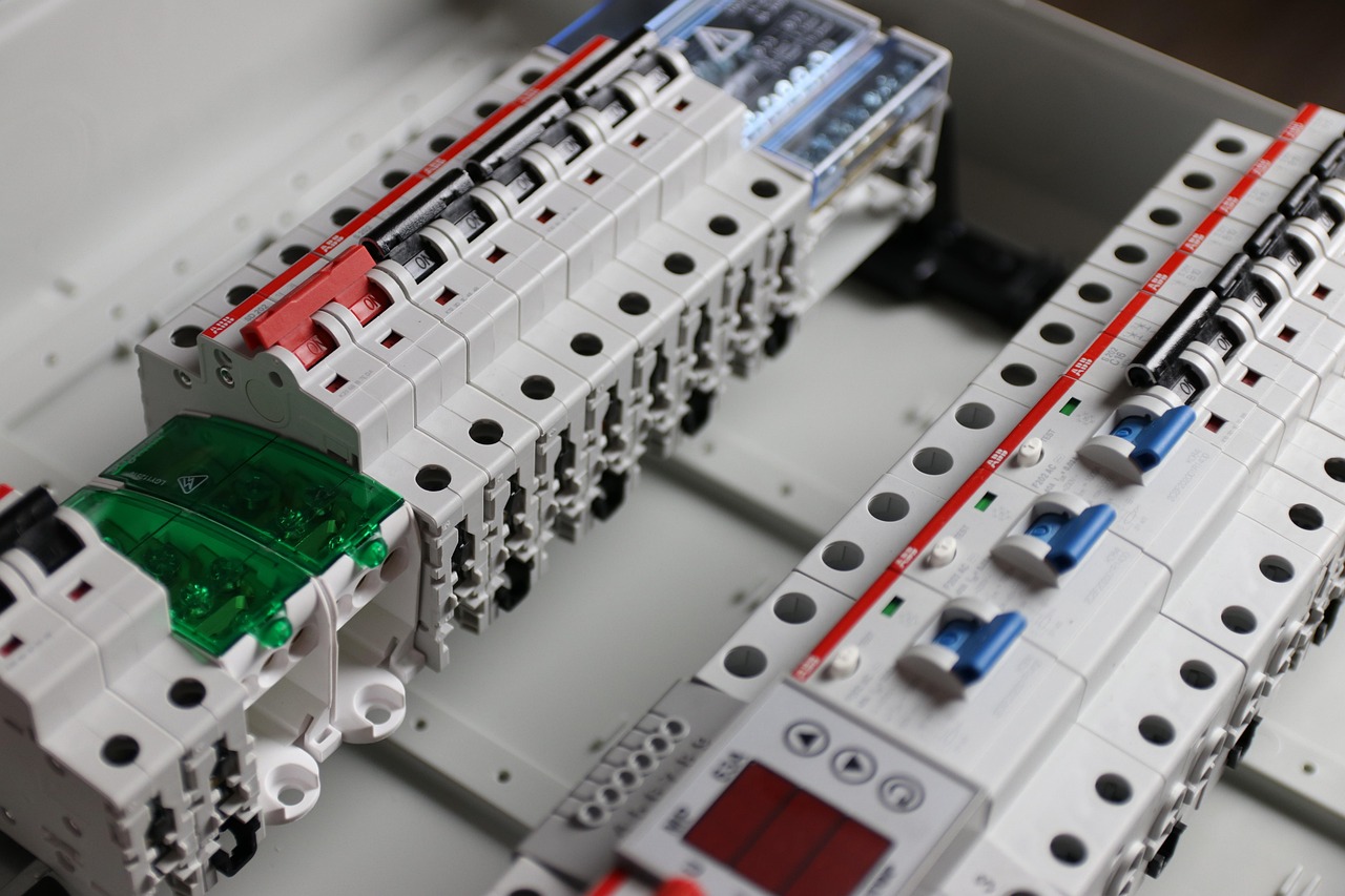 An electrician examining a residential 200-amp circuit breaker panel for EV charger installation.