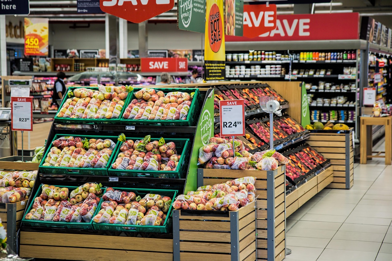 Comparison of bulk produce packaging next to standard grocery store sizes on a kitchen island.