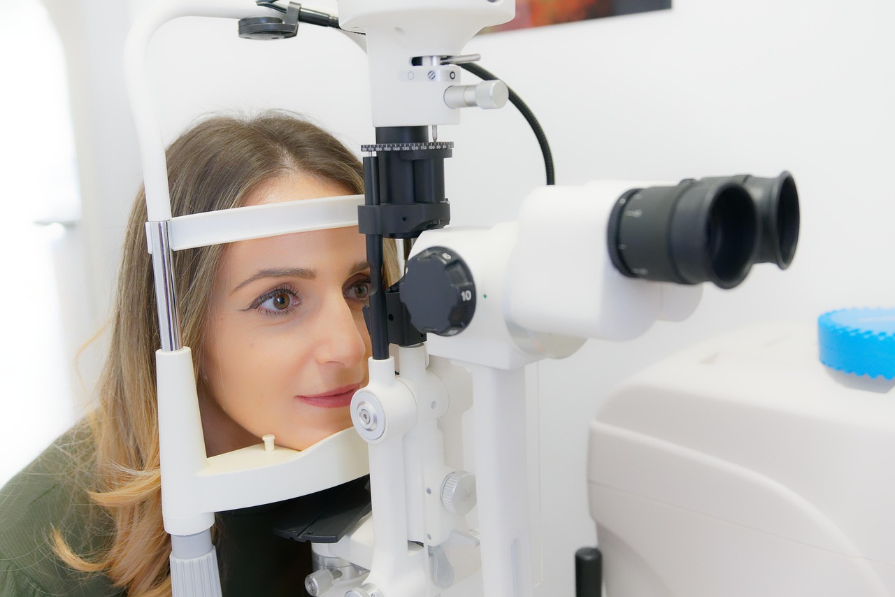 Prescription eyeglasses laying next to an optometrist prescription pad on an optical counter tray.