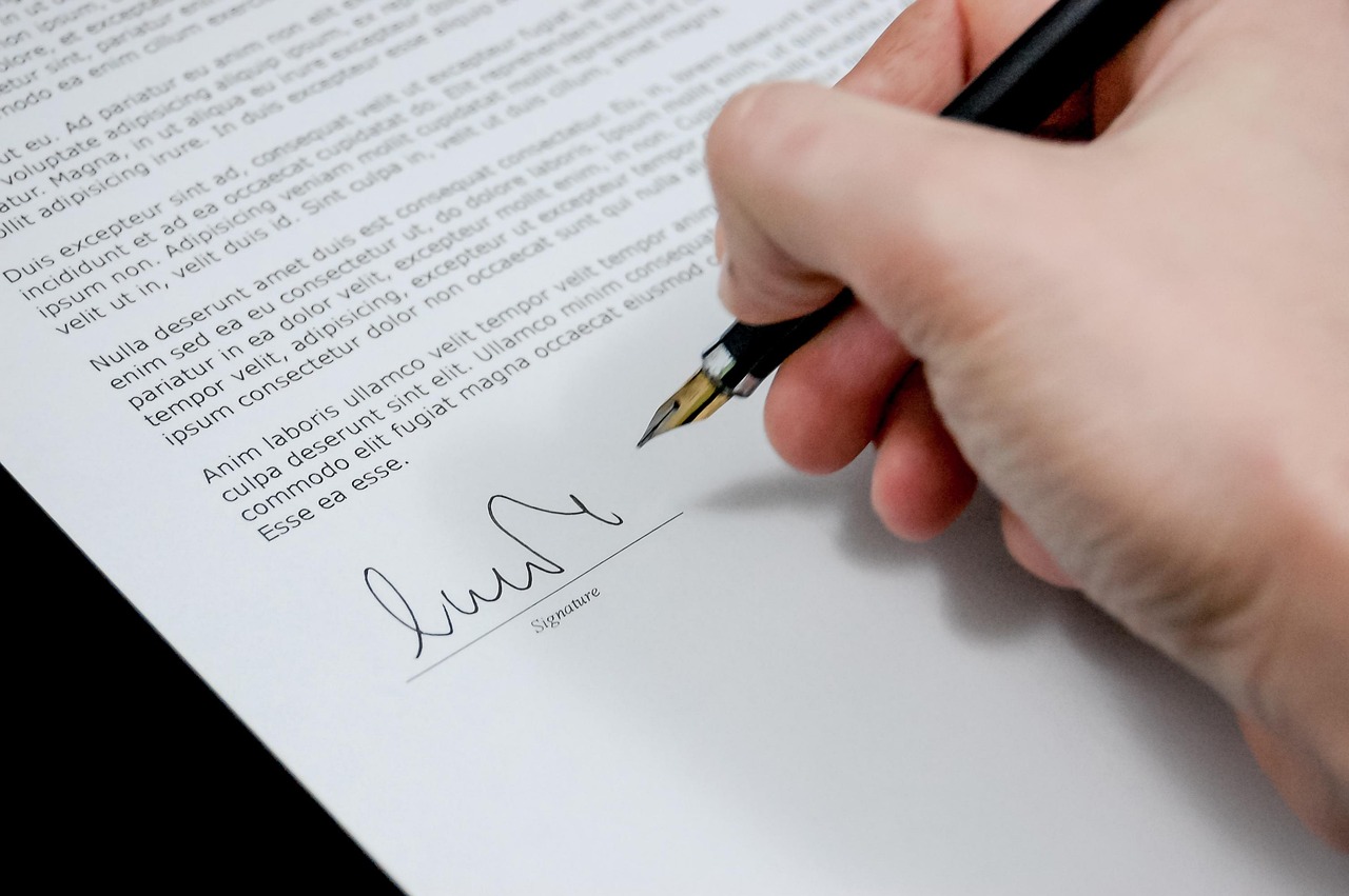 Close-up of a corporate worker reviewing layoff documents and severance agreement paperwork.